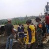 Babinsa Koramil Mandirancan saat membantu warga membangun bak penampungan air.